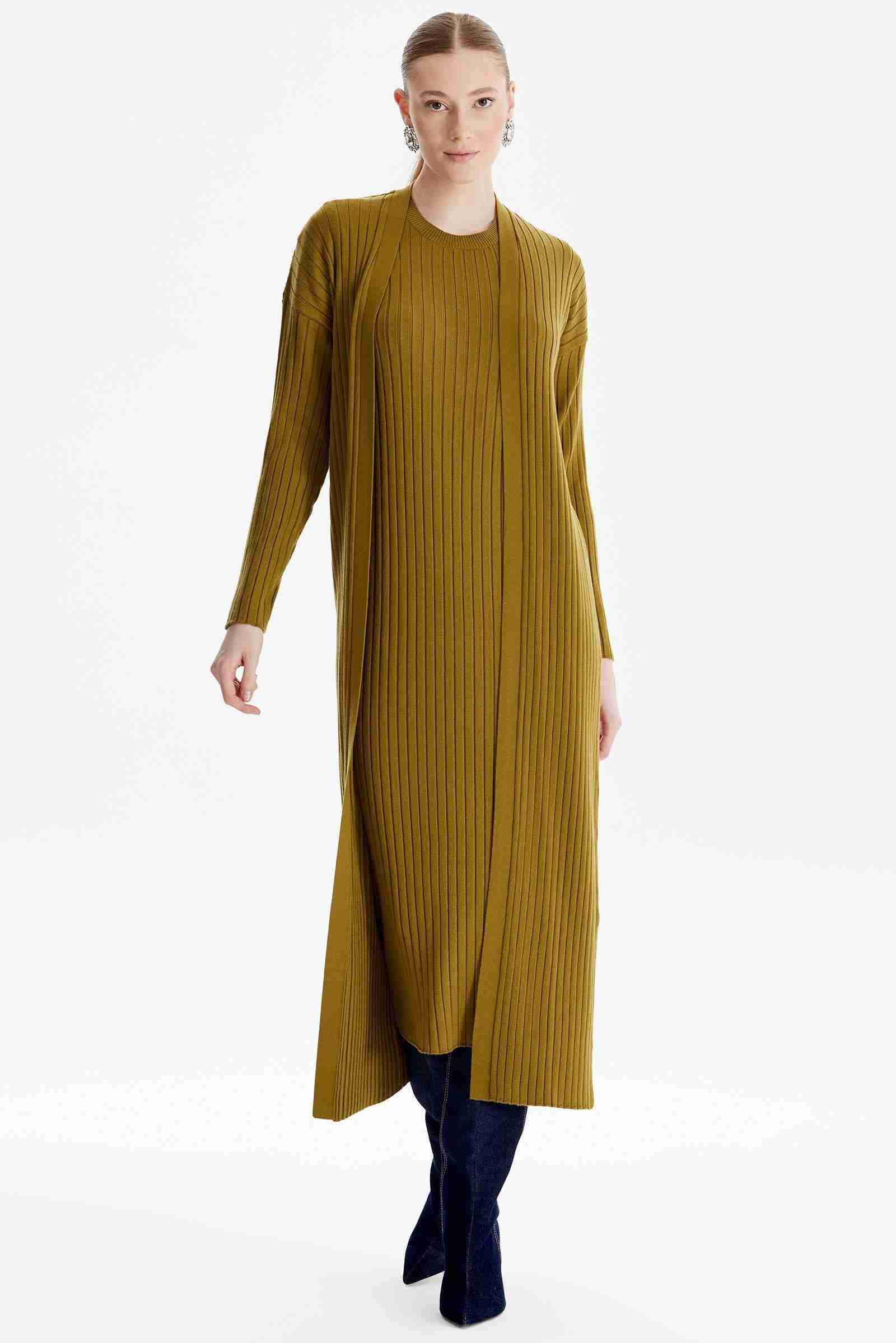 beyaz tenli kadın olive renkli hırka kombinli triko elbise modeli giyiyor
