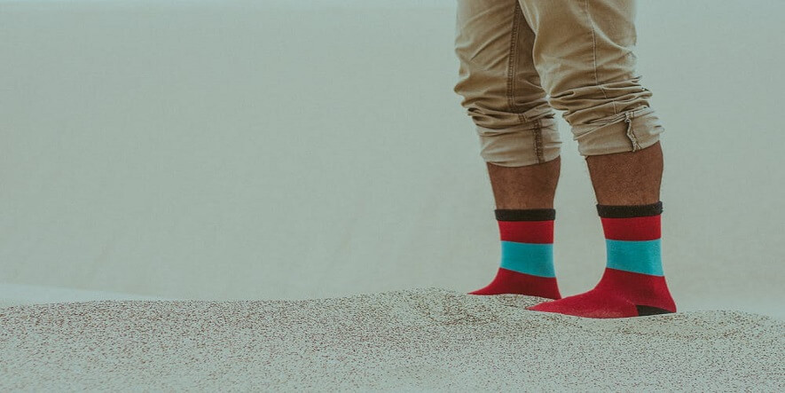 sahilspor hizmetiyle renkli ve desenli çorap giyen sahildeki insan.