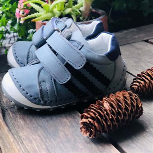 Lil Bugga Çika, gerçek deri, gri renk, kız ve erkek bebekler için ilk adım spor ayakkabısı, renkli fonda.