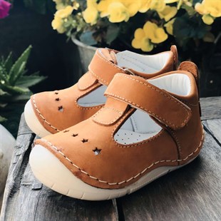 Lil Bugga Ponçik, gerçek deri, açık kahverengi, kız ve erkek bebekler için ilk adım ayakkabısı, renkli fonda.