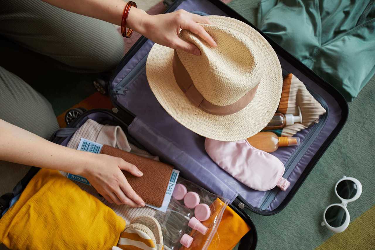 Bavul içerisindeki kıyafetleri düzenleyen bir kadın