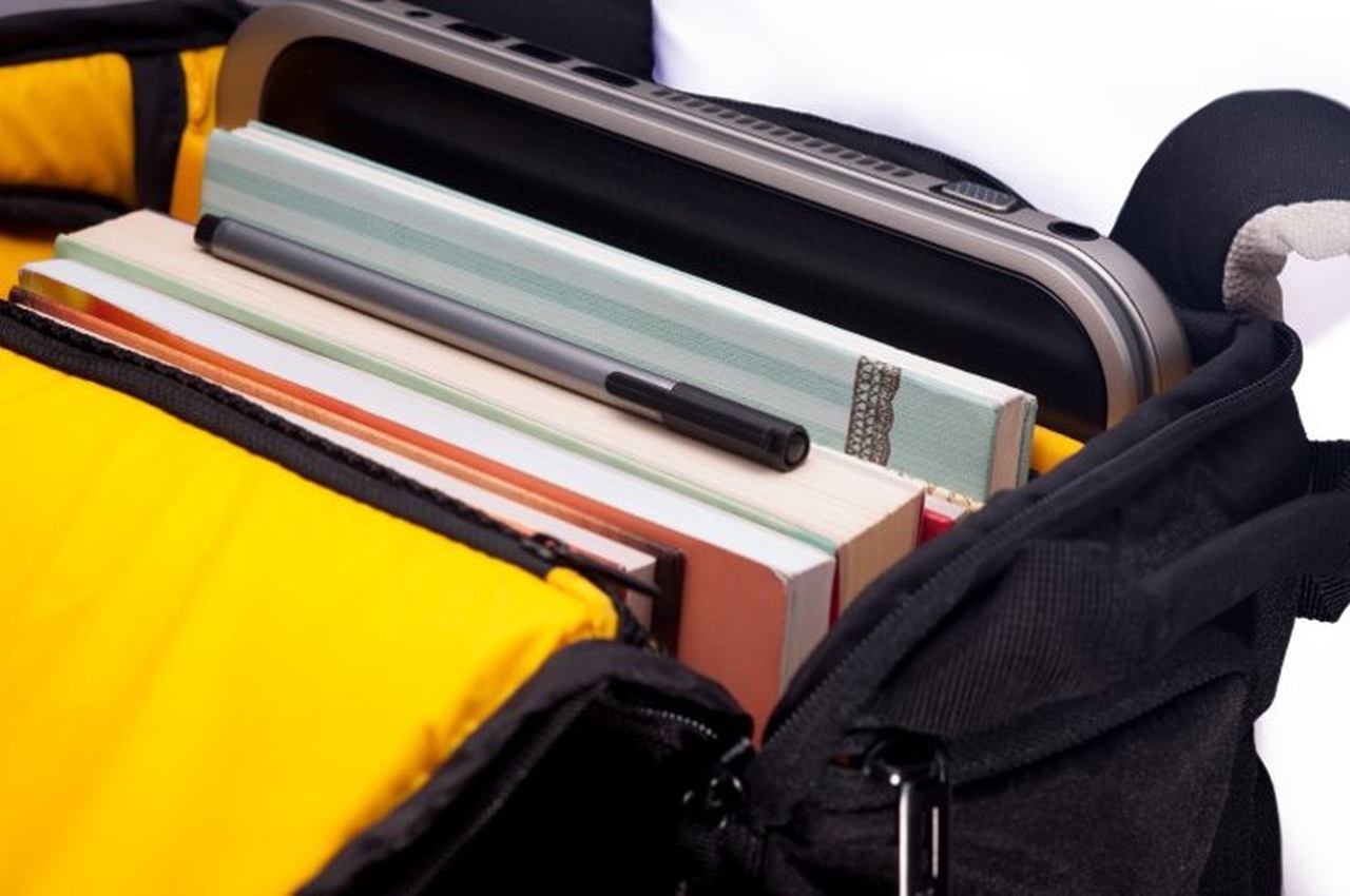 defterler ve bilgisayar içeren okul çantası