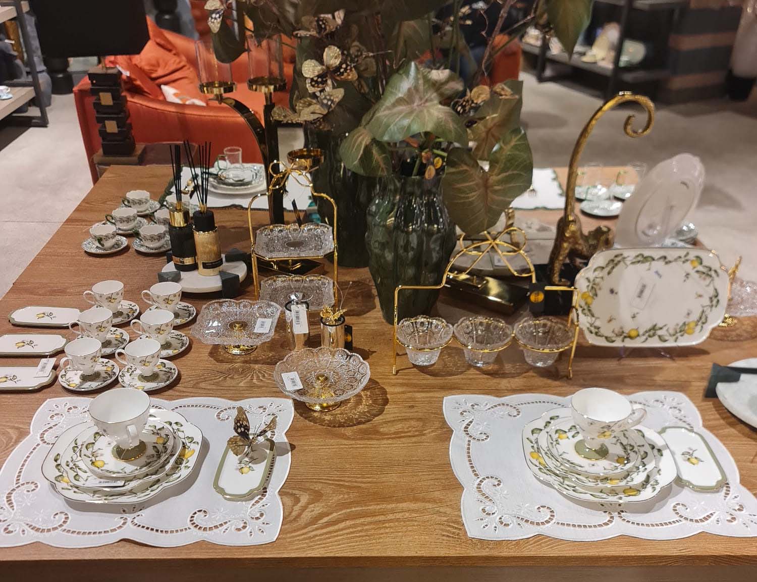 Çamlıca Home'da Mikasa Moor lüks kahve fincanı, yemek ve servis takımlarıyla oluşturulmuş zarif bir sofra sunumu. Masaüstünde limon desenli fincan setleri, altın detaylı tepsiler ve dekoratif objeler yer alıyor.