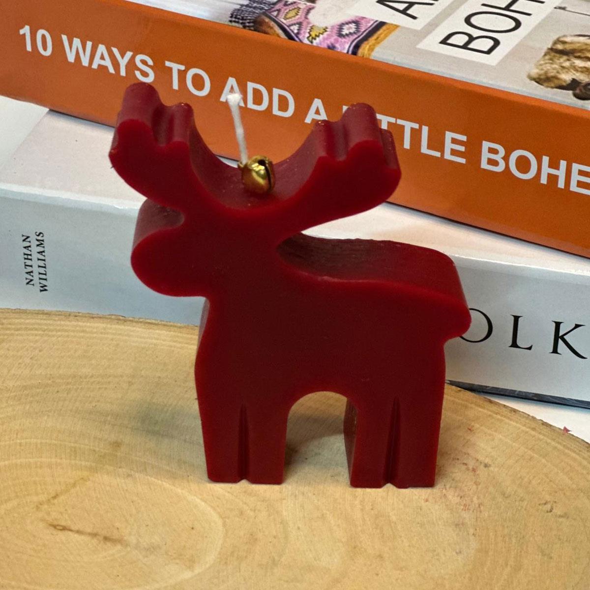 10 cm yüksekliğinde, kokulu kırmızı geyik figürlü mum. Yılbaşı ve kış konsepti masaüstü dekoratif mumu.