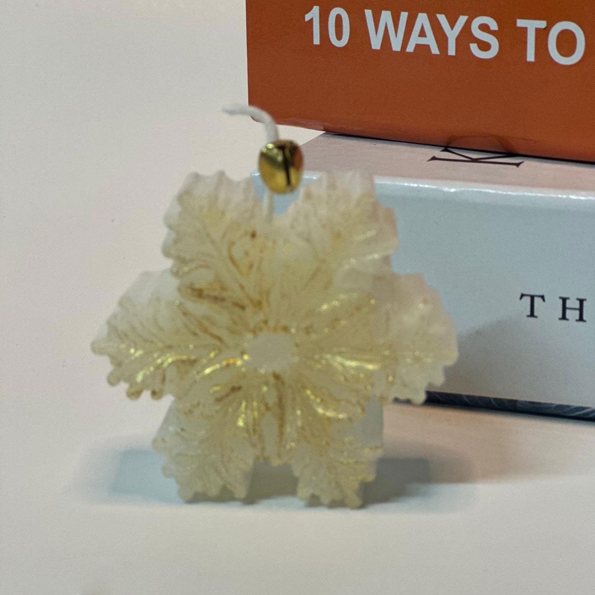 6 cm büyüklüğünde, gold (altın) yaldızlı ve kokulu küçük kar tanesi (yıldız) figürlü mum. Dekoratif yılbaşı ve kış konsepti mumu.