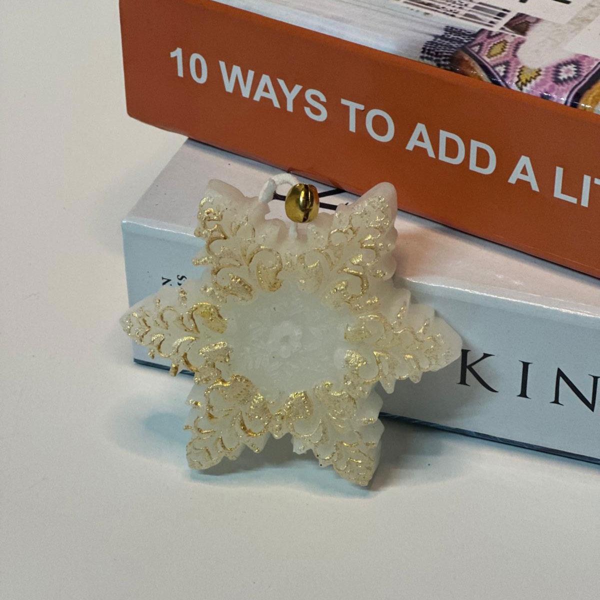 8 cm büyüklüğünde, gold (altın) yaldızlı ve kokulu kar tanesi (yıldız) figürlü mum. Dekoratif yılbaşı ve kış konsepti mumu.