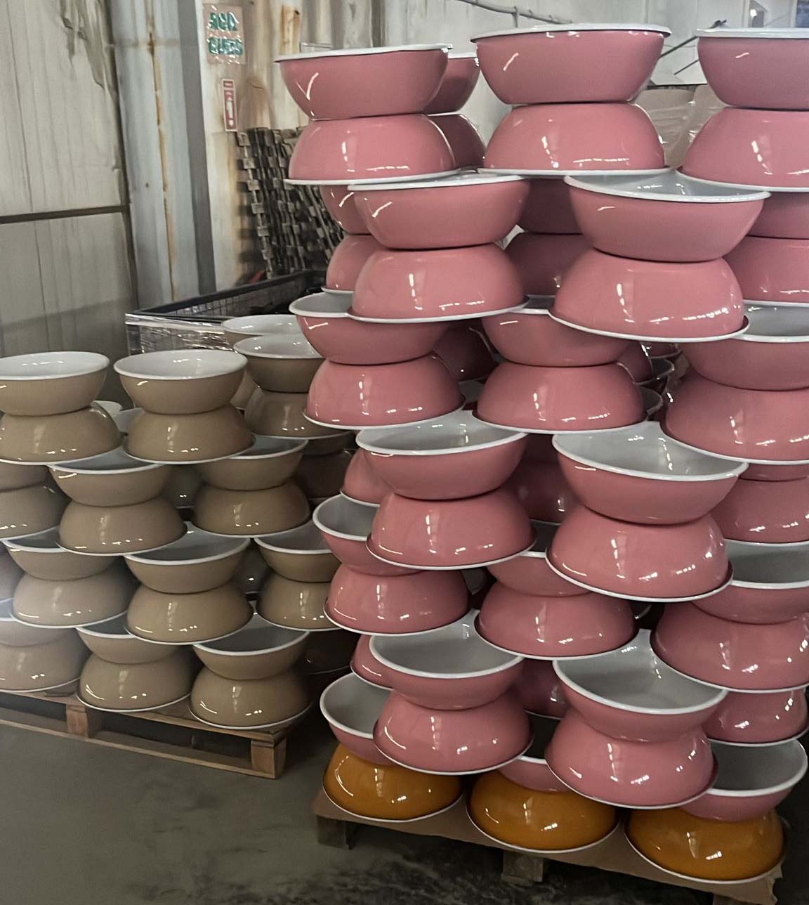 Farklı renklerdeki istiflenmiş emaye kaseler, ürünlerin çok yönlülüğünü ve renk çeşitliliğini vurguluyor.