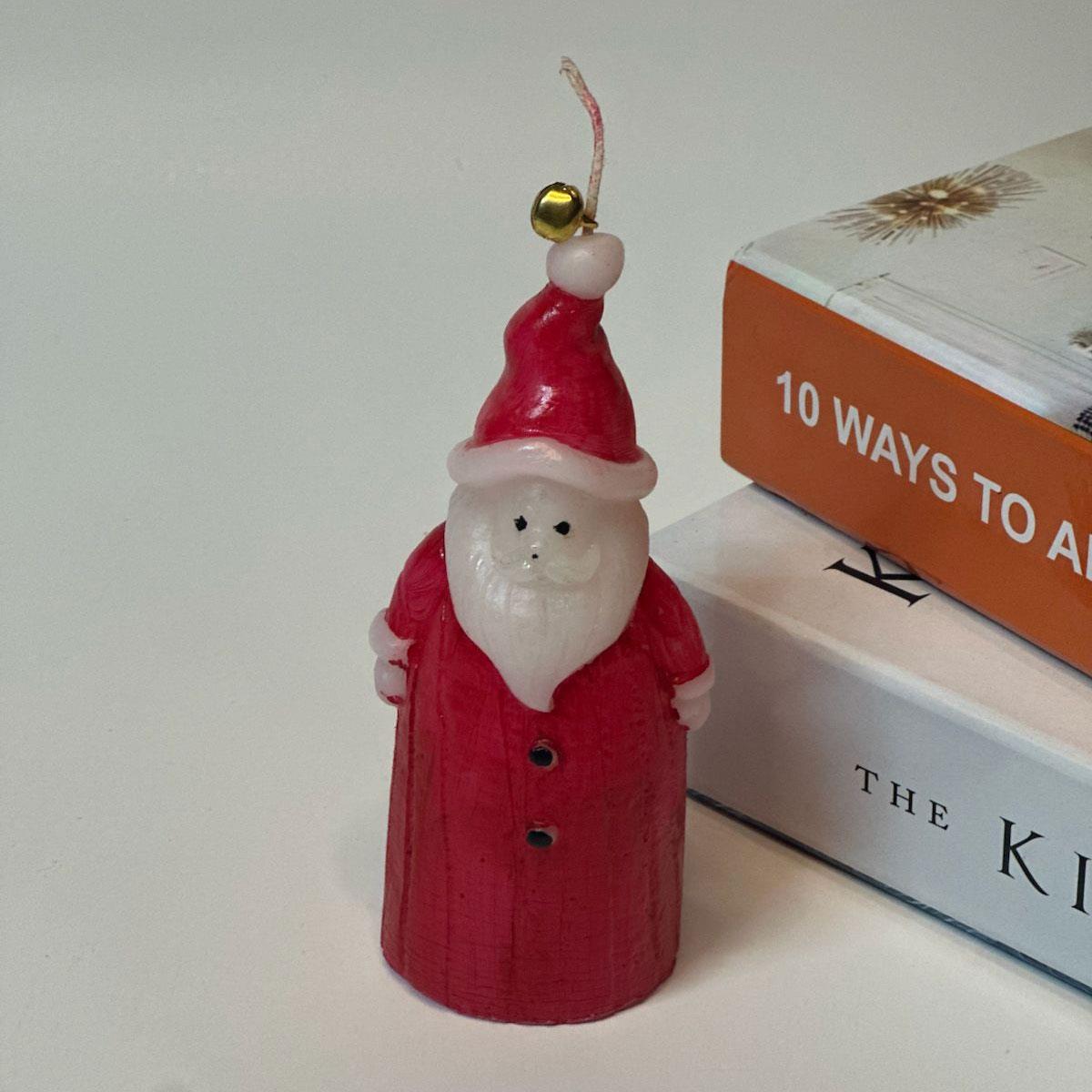 14 cm yüksekliğinde kokulu Noel Baba figürlü mum. Kırmızı ve beyaz renkli, dekoratif yılbaşı mumu.