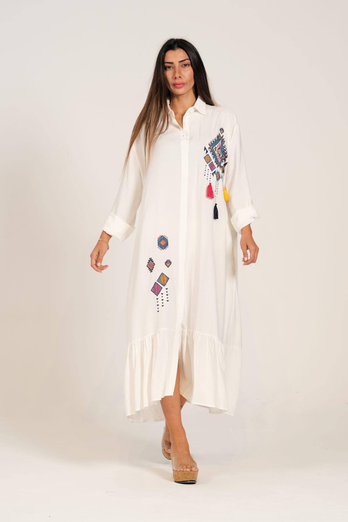 فستان أبيض مطرز بشراشيب مطرزة مع تطريزات مطرزة على الصدر والتنورة وفستان قميص طويل مزركش مع كتاف على الأكمام