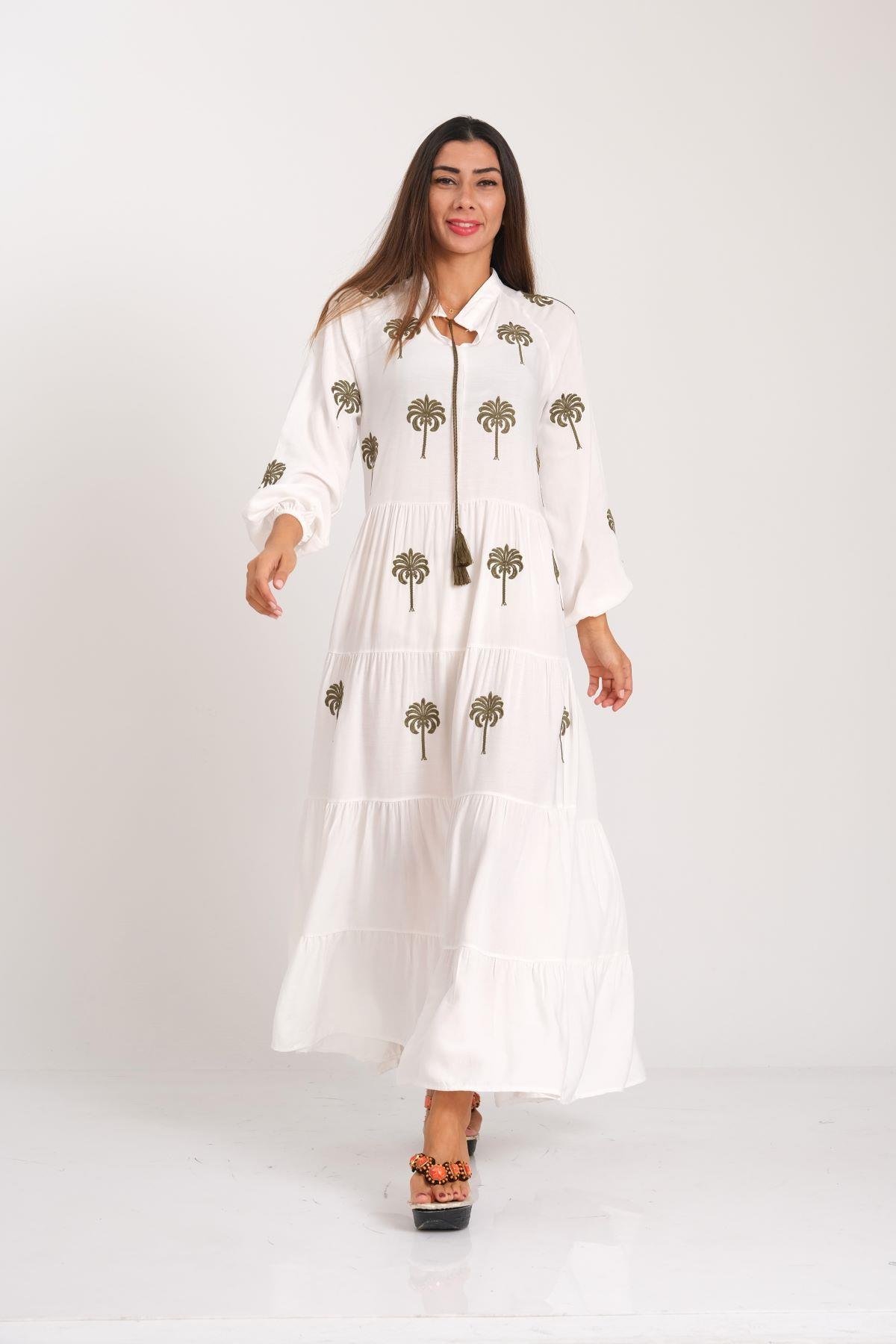 فستان طويل أبيض بتطريزات النخيل على الأمام والأكمام وتنورة مطوية