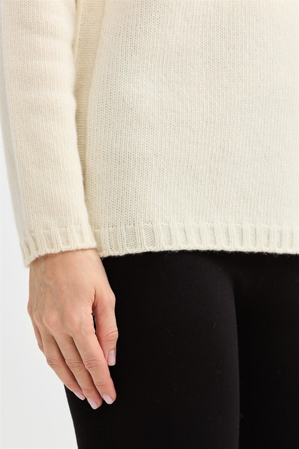 Женский шерстяной свитер с круглым вырезом и вязкой косичка на рукаве молочный 