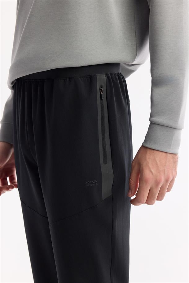 Siyah Beli Lastikli Yandan Fermuarlı Cepli Flexi Baskı Detaylı Parçalı Teknik Kumaş Jogger