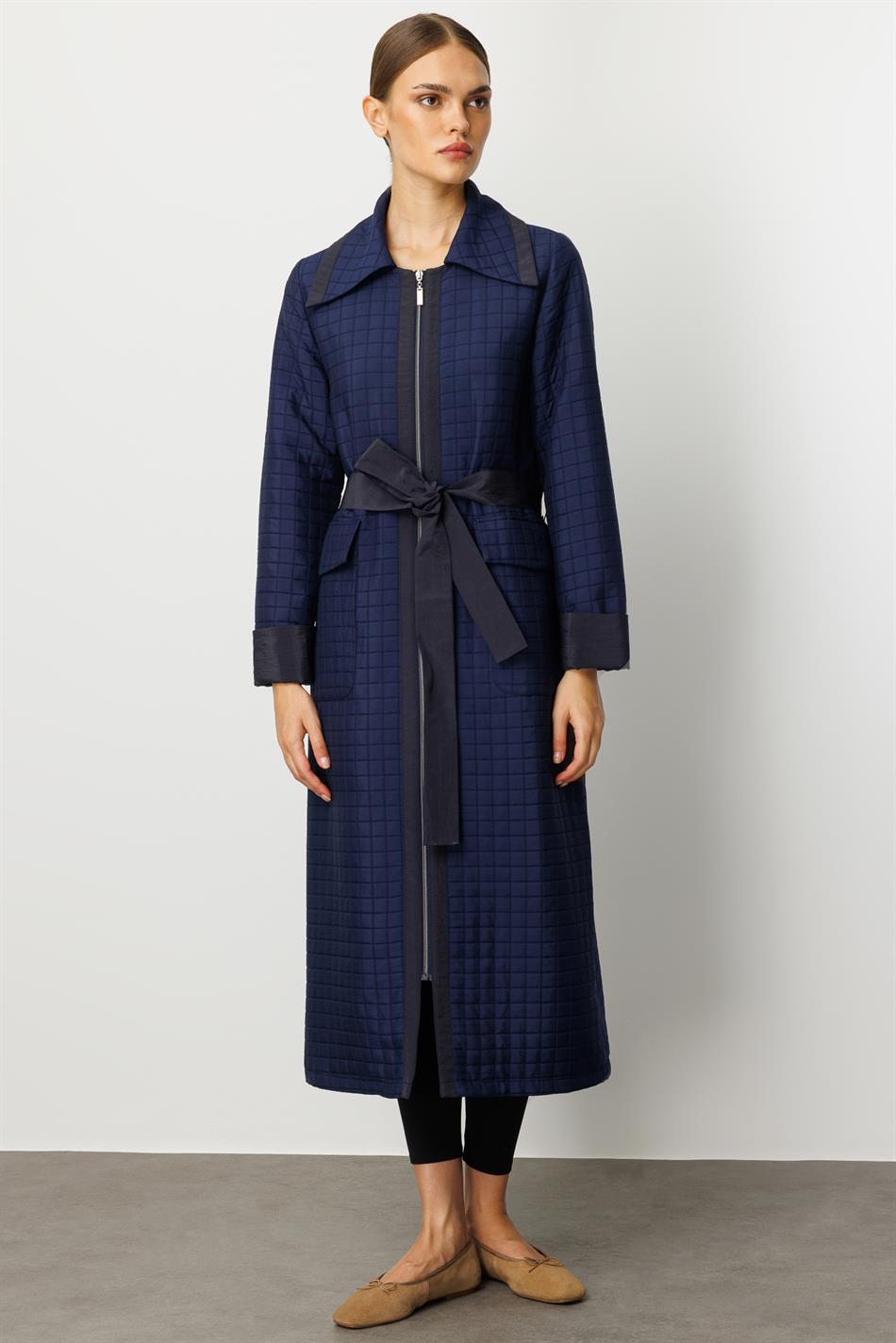 Tünd göy rəngdə xəndək palto, jakkardlı sırğalı və sadə parçadan hazırlanmışdır, tam astarlıdır, mövsümi istifadə üçün uyğundur.