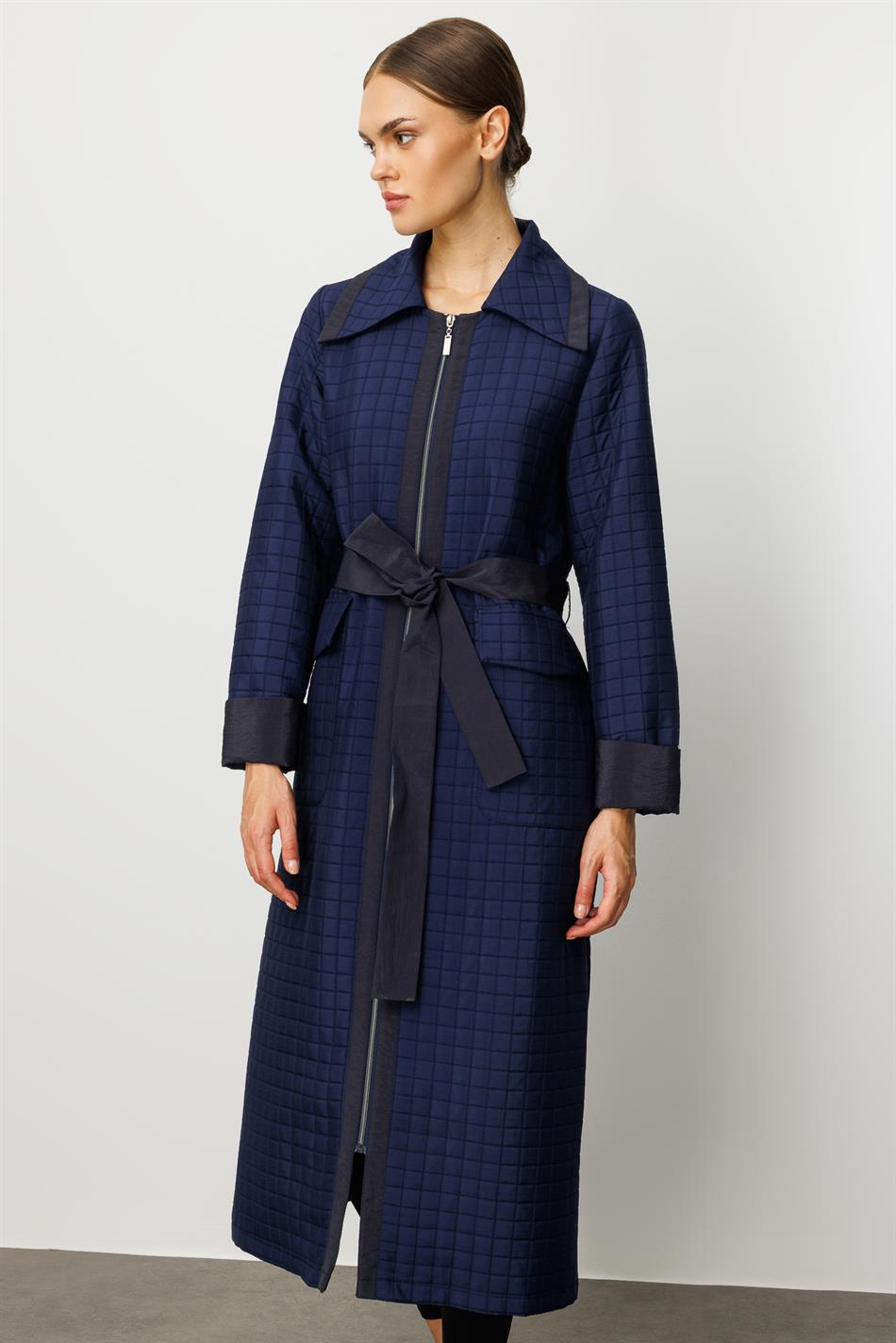 Tünd göy rəngdə xəndək palto, jakkardlı sırğalı və sadə parçadan hazırlanmışdır, tam astarlıdır, mövsümi istifadə üçün uyğundur.