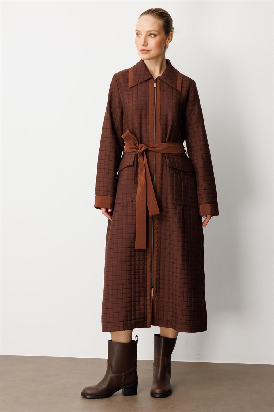 Qəhvəyi rəngdə, jakkardlı yorğanlı və sadə bəzəkli parça ilə xəndək palto, tam astarlı, mövsümi istifadə üçün uyğundur.