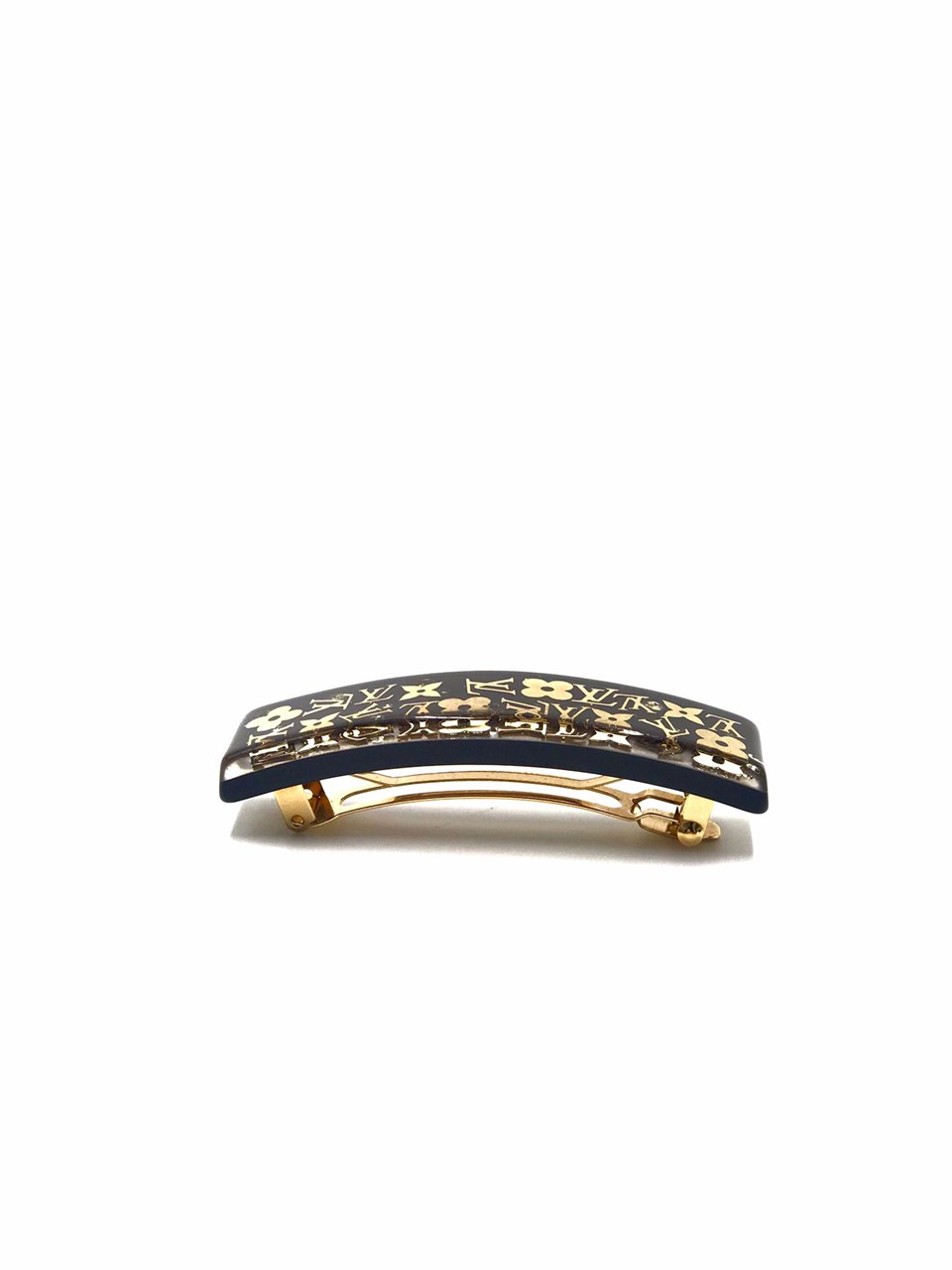 LOUIS VUITTON, a black acrylic and gold hair clip. - Bukowskis