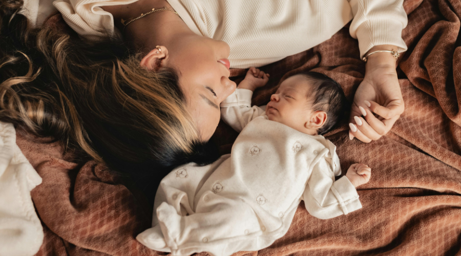 Yeni doğan bebeği ile uzanan anne