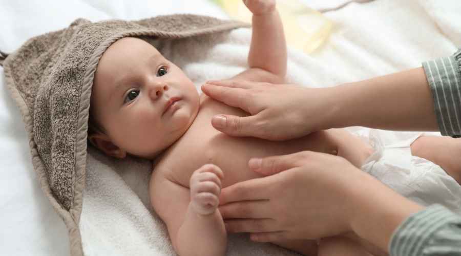 Bebek yağı ile annesi tarafından masaj yapılan bir bebek