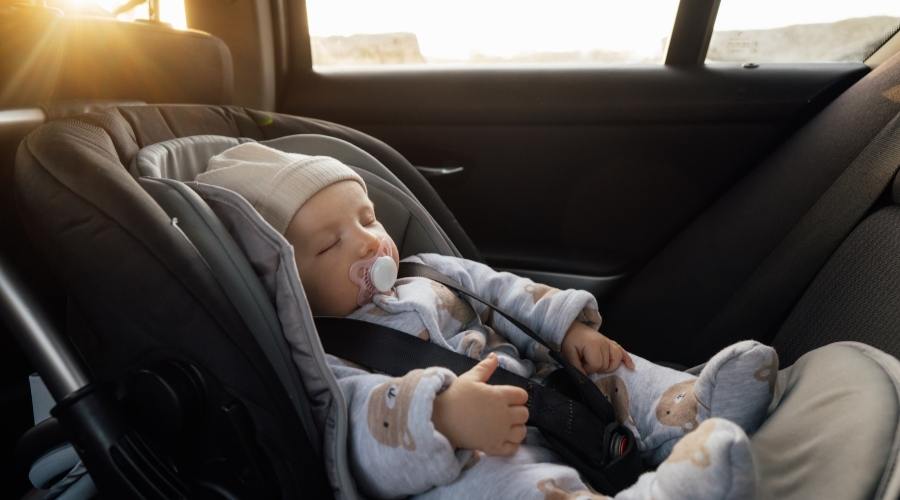 Bebek oto koltuğunda uyuyan bebek küçük çocukla arabada güvenli yolculuk Küçük bebek emniyet kemeriyle güvenli oto koltuğuna bağlanmış Yolculuk yaşam tarzı çocuk bakımı taşıma arkaya dönük koltuk.
