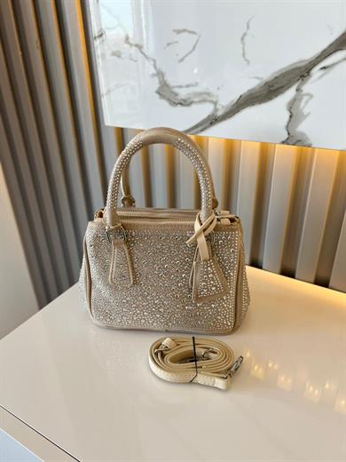 DİAMOND TAŞLİ ÇANTA BEJ İçerisinde bir adet fermuarlı cep bulunmaktadır ve bir adet Gold detaylı askı bulunmaktadır