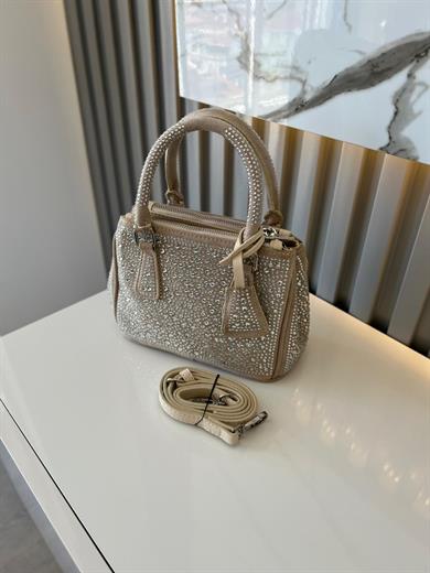 DİAMOND TAŞLİ ÇANTA BEJ İçerisinde bir adet fermuarlı cep bulunmaktadır ve bir adet Gold detaylı askı bulunmaktadır