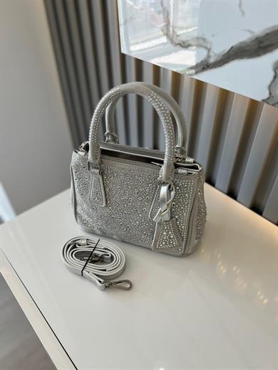 DİAMOND TAŞLİ ÇANTA GÜMÜŞ İçerisinde bir adet fermuarlı cep bulunmaktadır ve bir adet Gold detaylı askı bulunmaktadır