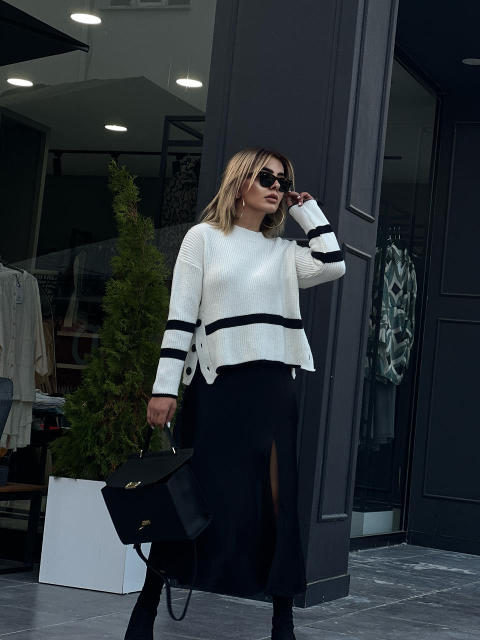Off-white rib knit sweater with side buttons.