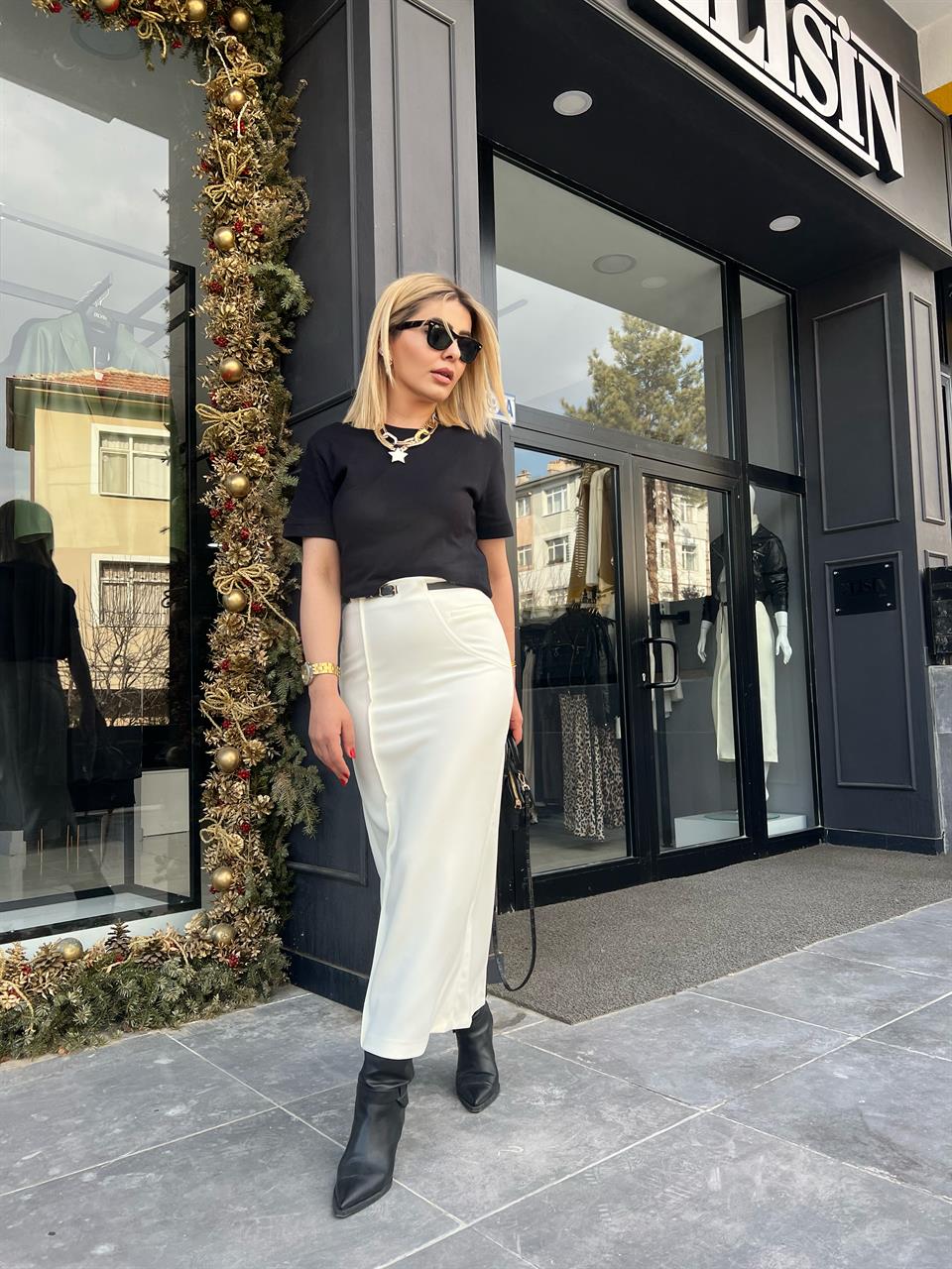 Off-white skirt with side zipper, stitching and slit detail, and belt.