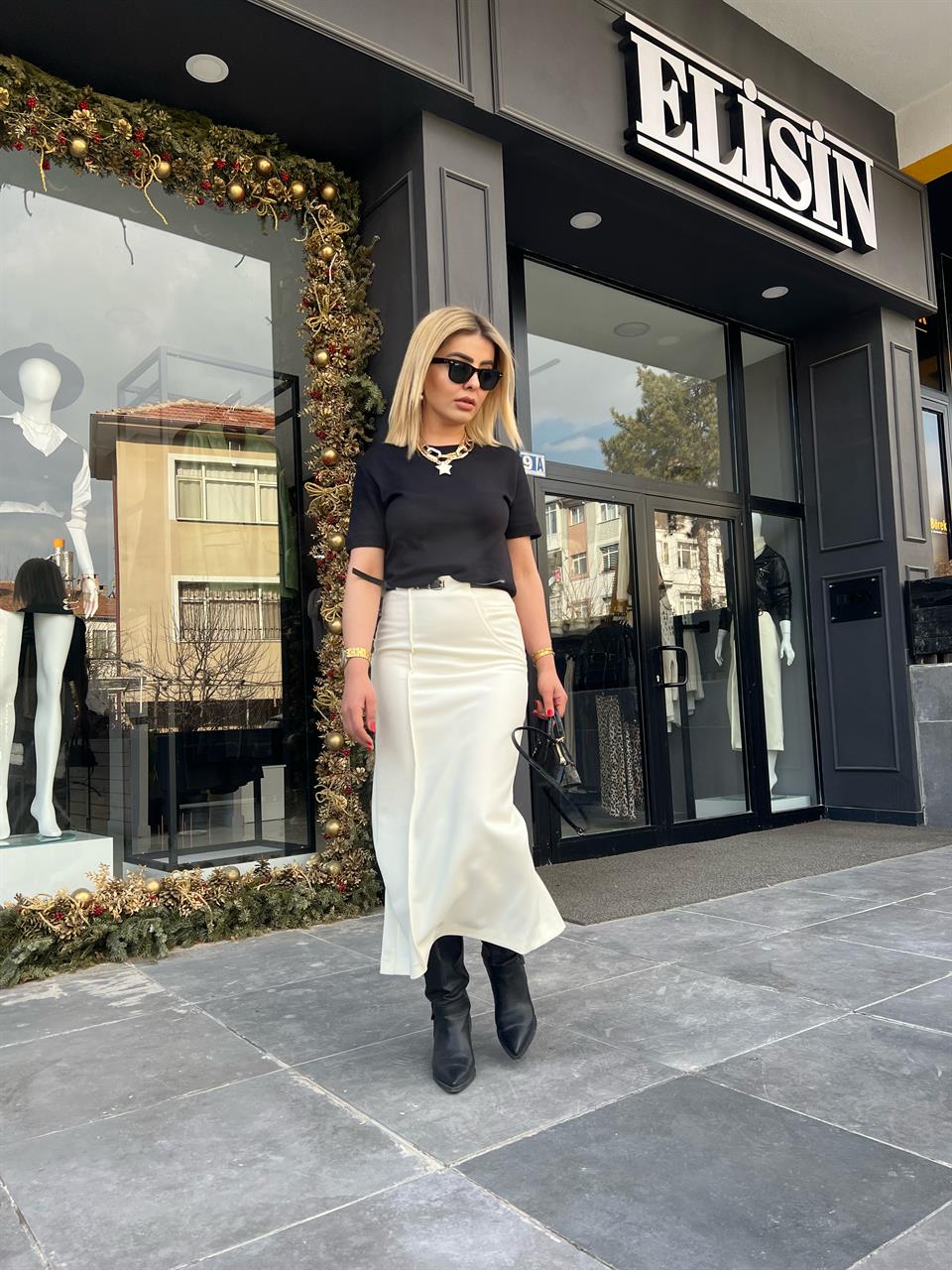 Off-white skirt with side zipper, stitching and slit detail, and belt.
