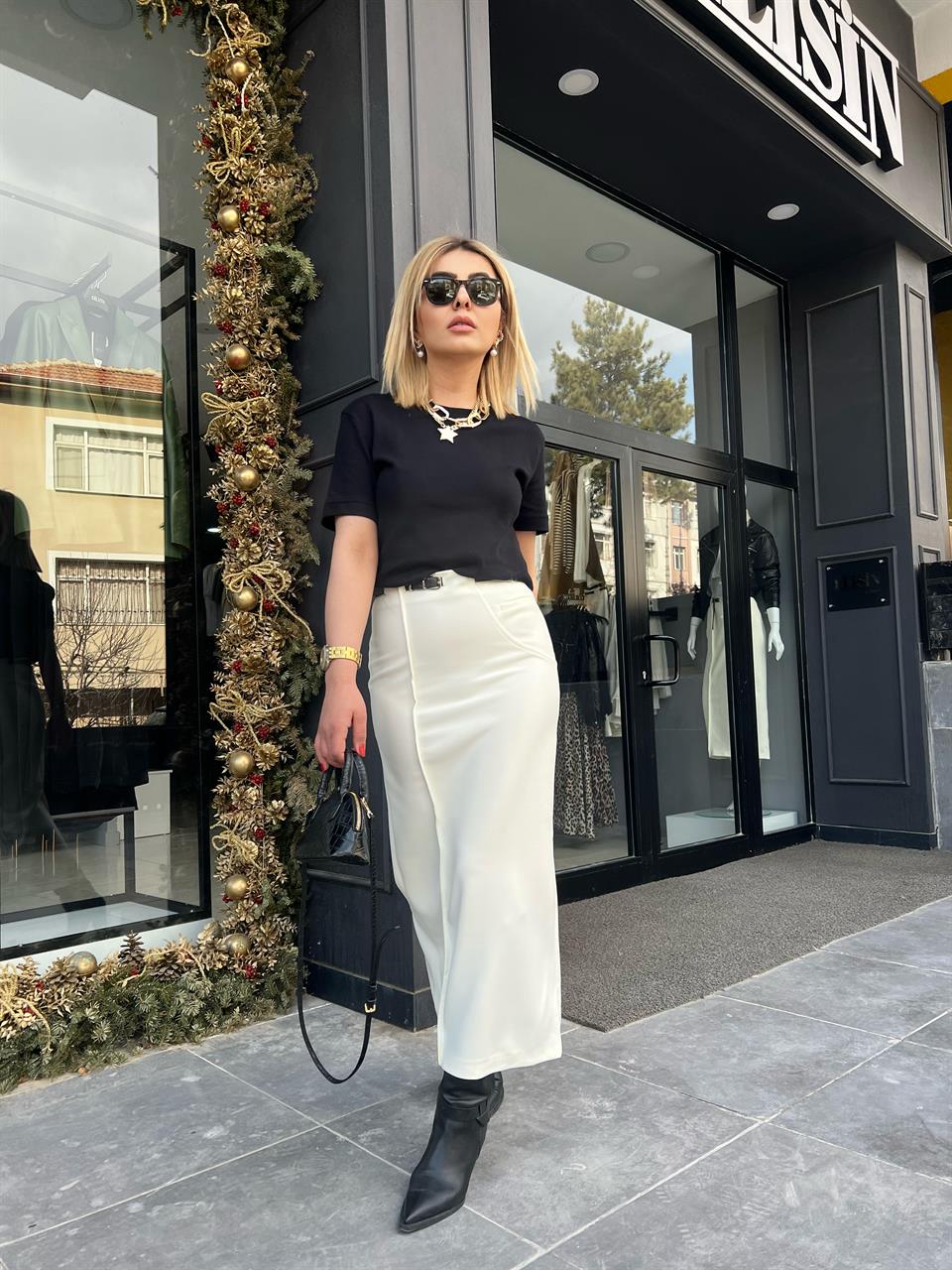 Off-white skirt with side zipper, stitching and slit detail, and belt.