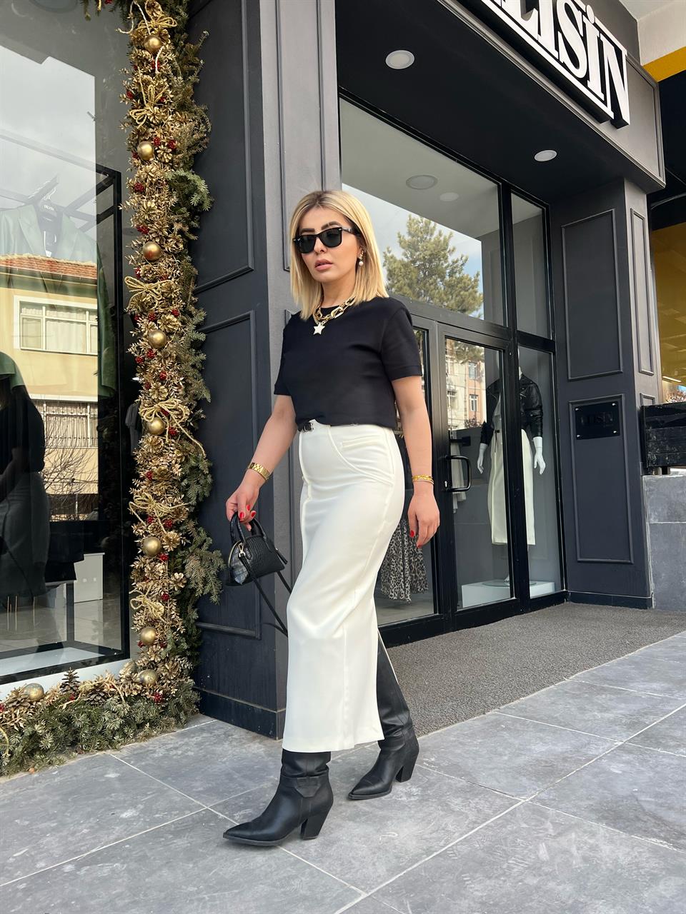 Off-white skirt with side zipper, stitching and slit detail, and belt.