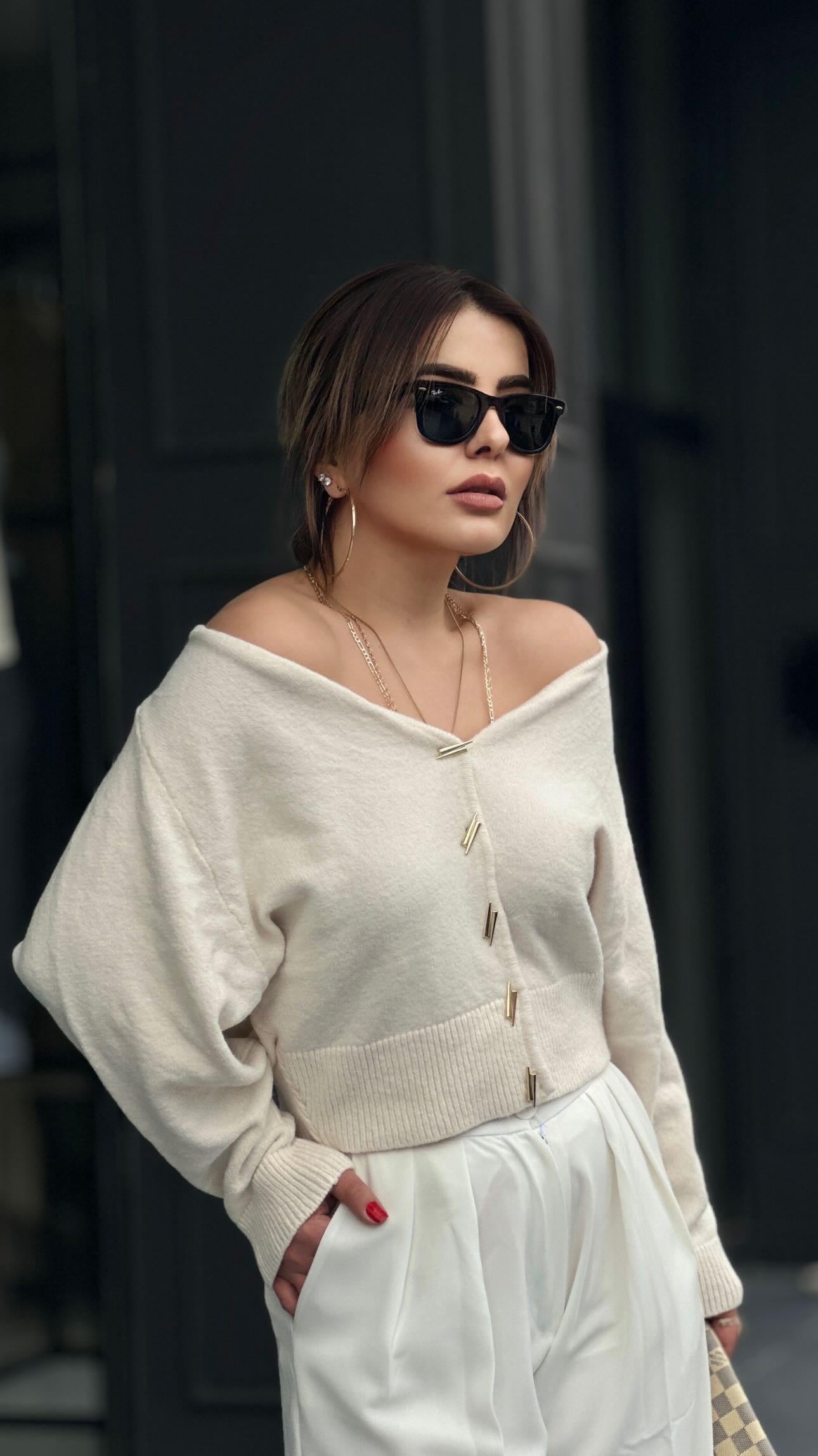 كارديجان كريمي اللون بياقة على شكل حرف V مزين بأزرار ذهبية وحواف ذهبية