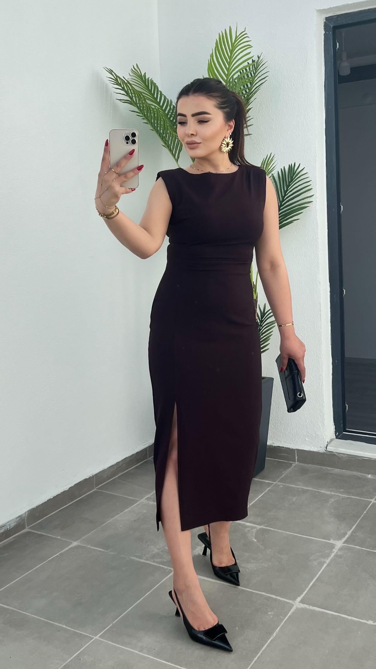 Plum-colored dress with draped waist, slit detail, and shoulder pads.