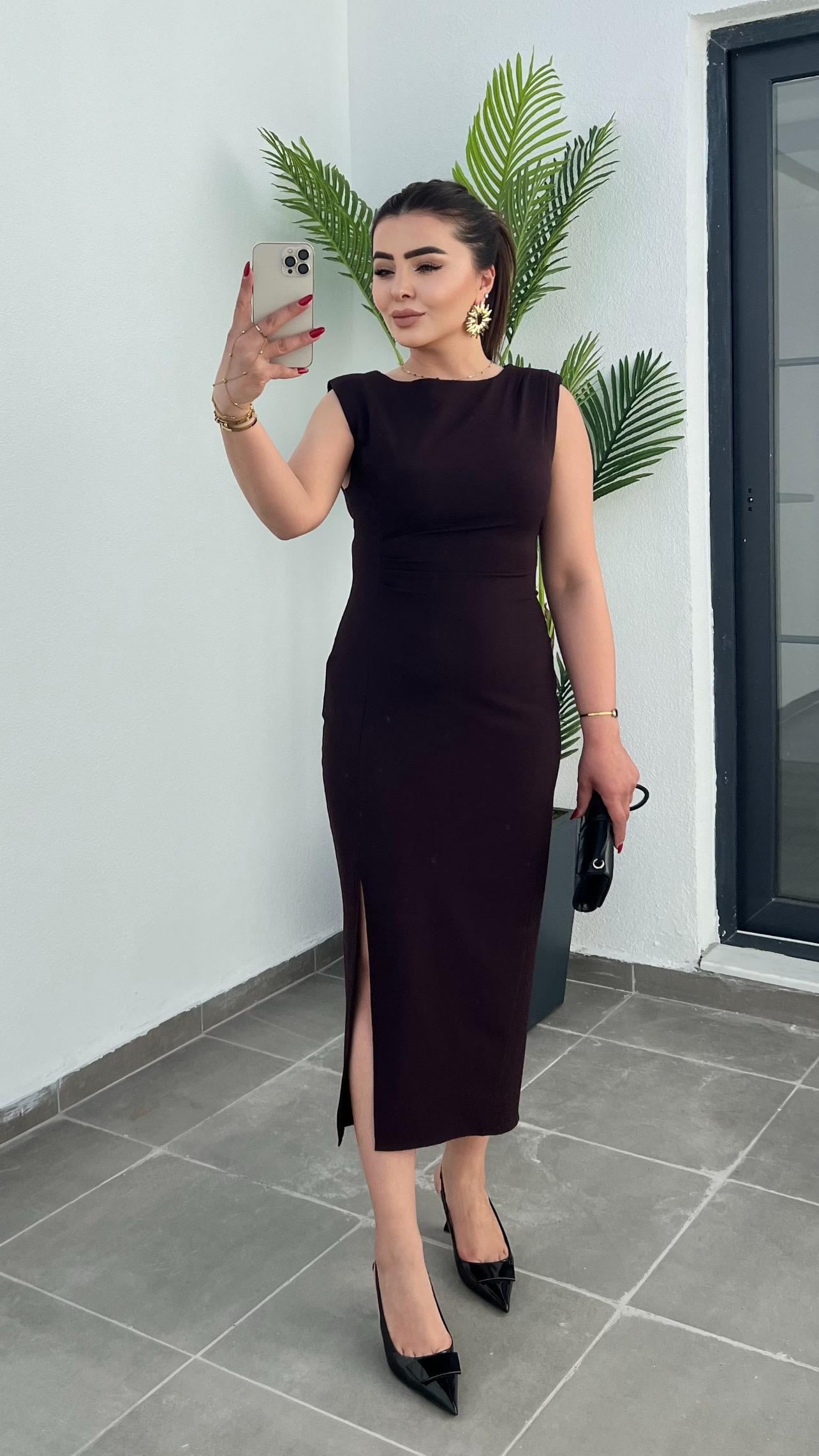 Plum-colored dress with draped waist, slit detail, and shoulder pads.