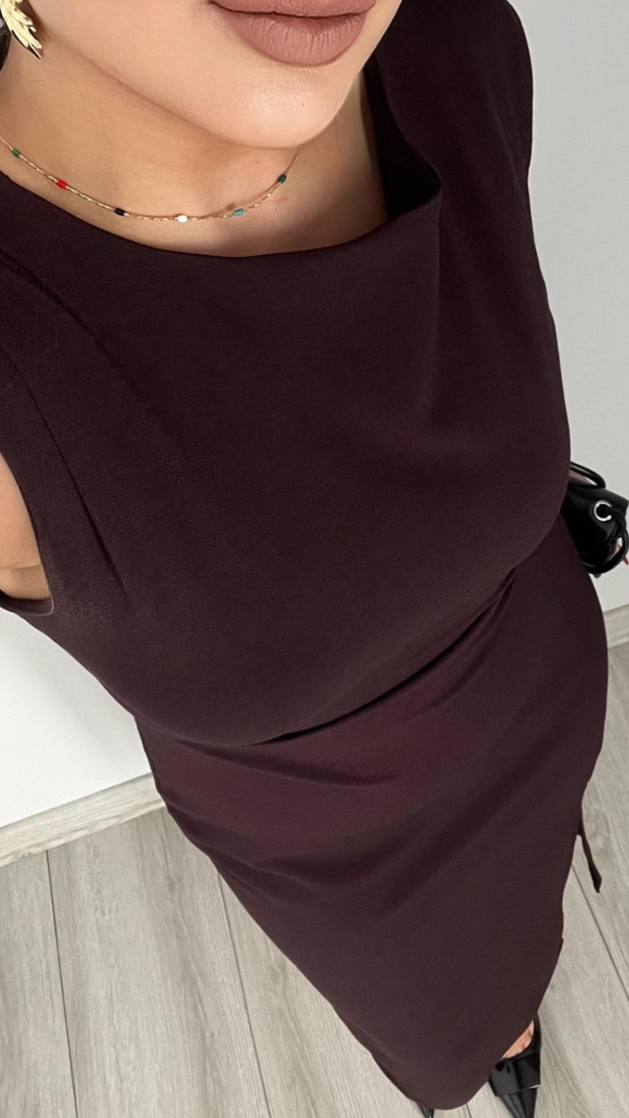 Plum-colored dress with draped waist, slit detail, and shoulder pads.