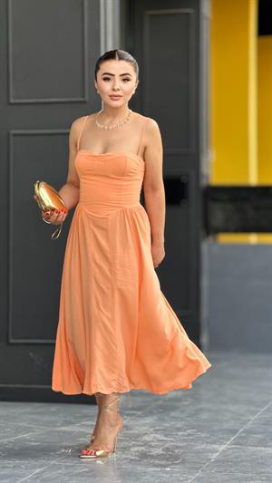 Salmon-colored, strappy princess dress with bust cups.