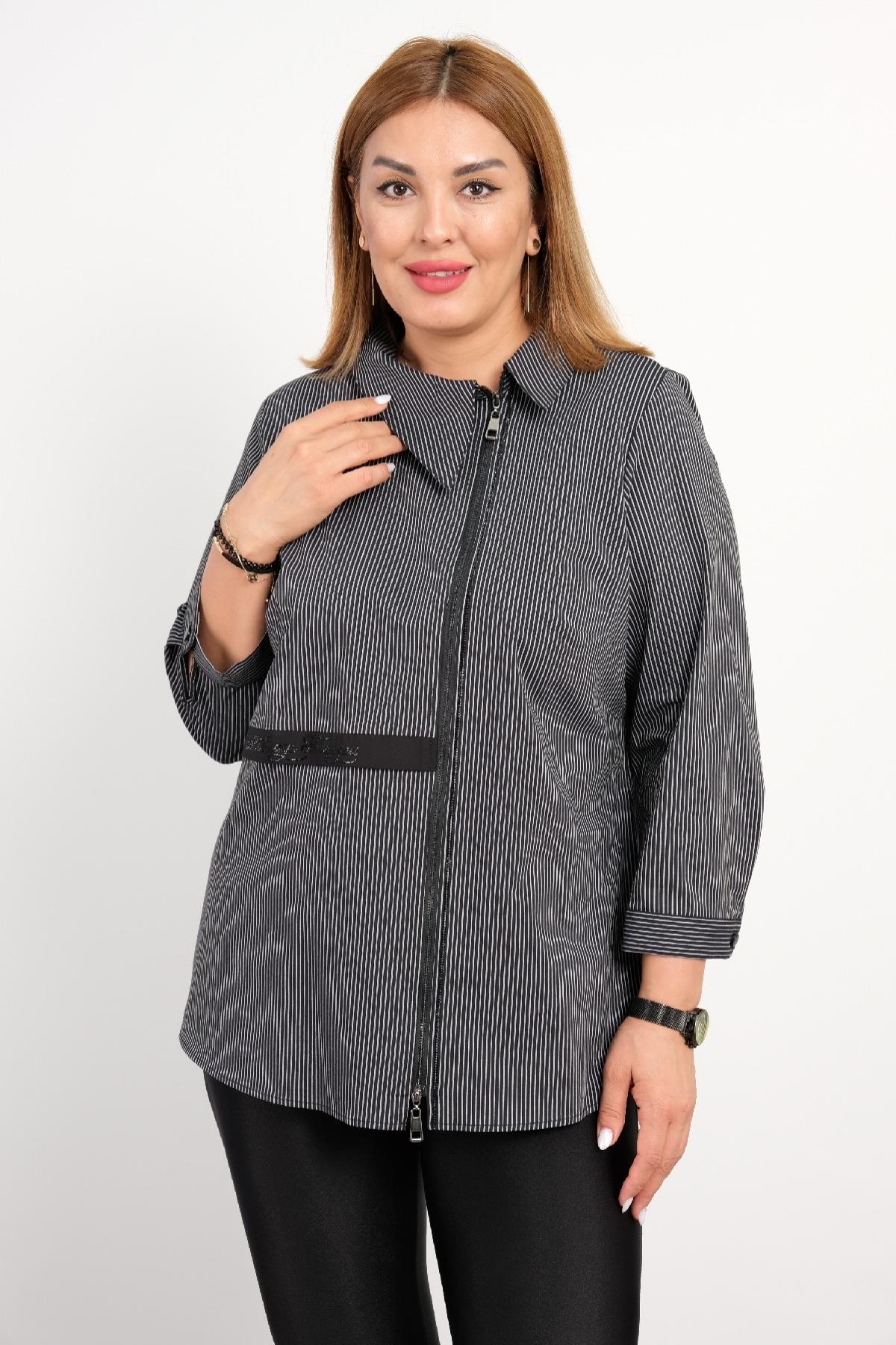  Bu model siyah beyaz ince çizgili bir bluz giymektedir. Bluzun ön kısmında yakadan aşağıya kadar uzanan fermuar bulunmaktadır. Geniş ve rahat bir kesime sahip olan bu bluzun kolları 3/4 uzunluğundadır. Bluzun bel kısmında, bel hattını belirginleştir
