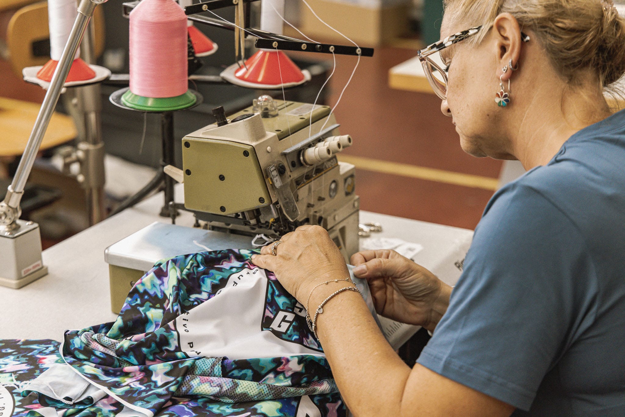 Fabrikada dikiş makinesinde bisiklet forması diken kadın