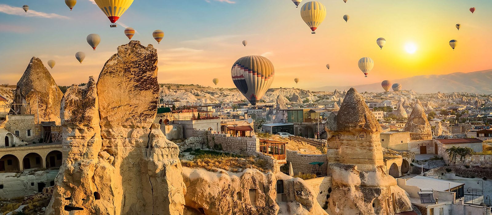 Hot air balloons rising over Cappadocia at sunrise
