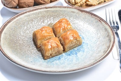 Seyidoğlu Cevizli Ev Baklavası 1 Kg — kat kat yufka, bol ceviz dolgulu kare dilimler tabakta servis