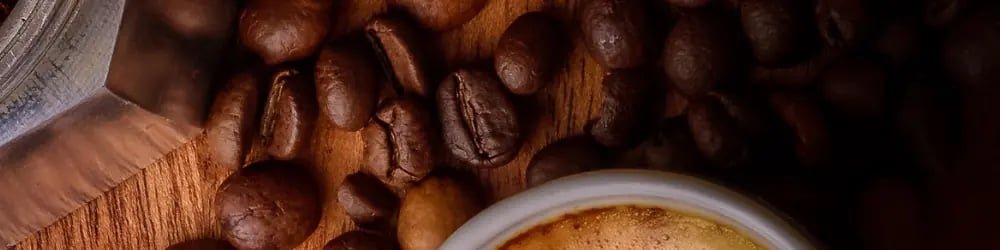 Decaf kahveler için kahve çekirdekleri ve krema tabakalı fincanda kahve