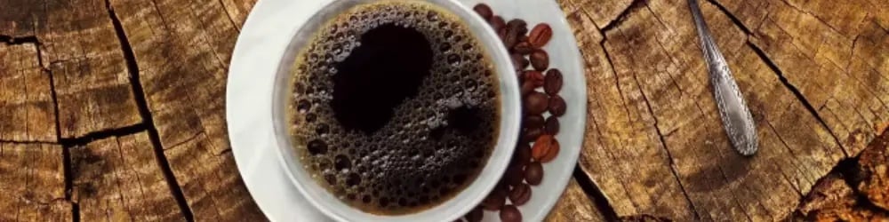 Dünya Kahve Günü için ahşap zeminde tepeden Türk kahvesi fincanı