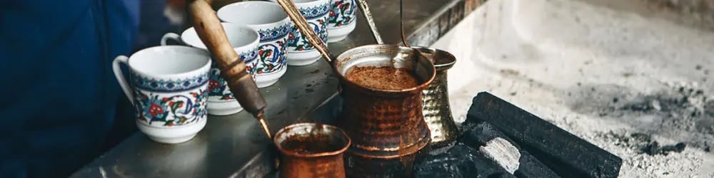 Dünya Kahve Günü için bakır cezveler ve desenli Türk kahvesi fincanları