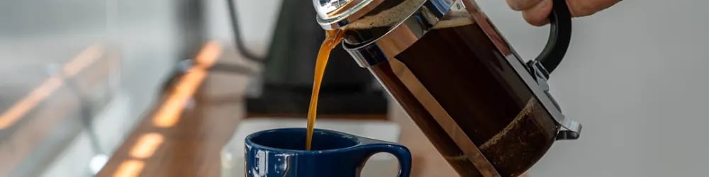 French press'te yapılan filtre kahvenin mavi kupaya dökülüşü