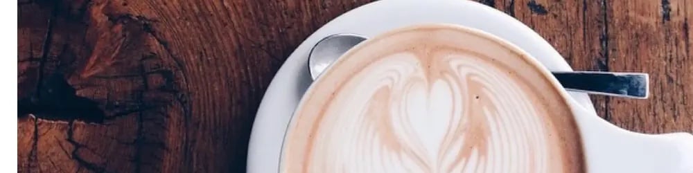 Sütlü kahve yapımında beyaz fincanda kalp figürlü latte art