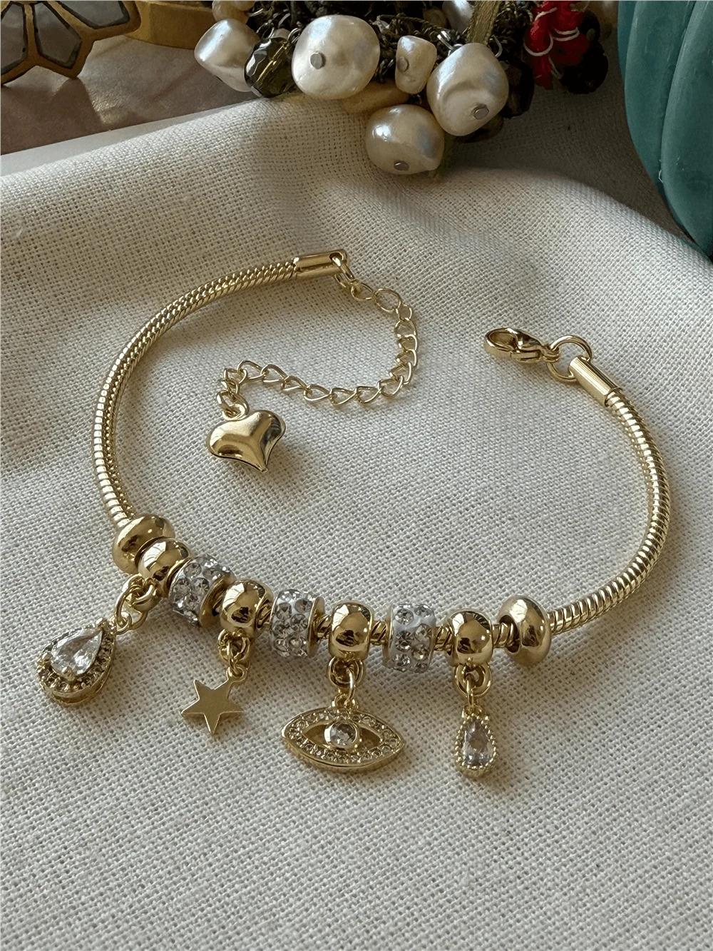 VİP SERİ ŞEFFAF TAŞLI GÖZ MODEL YILDIZI DETAYLI GOLD CHARM BİLEKLİK