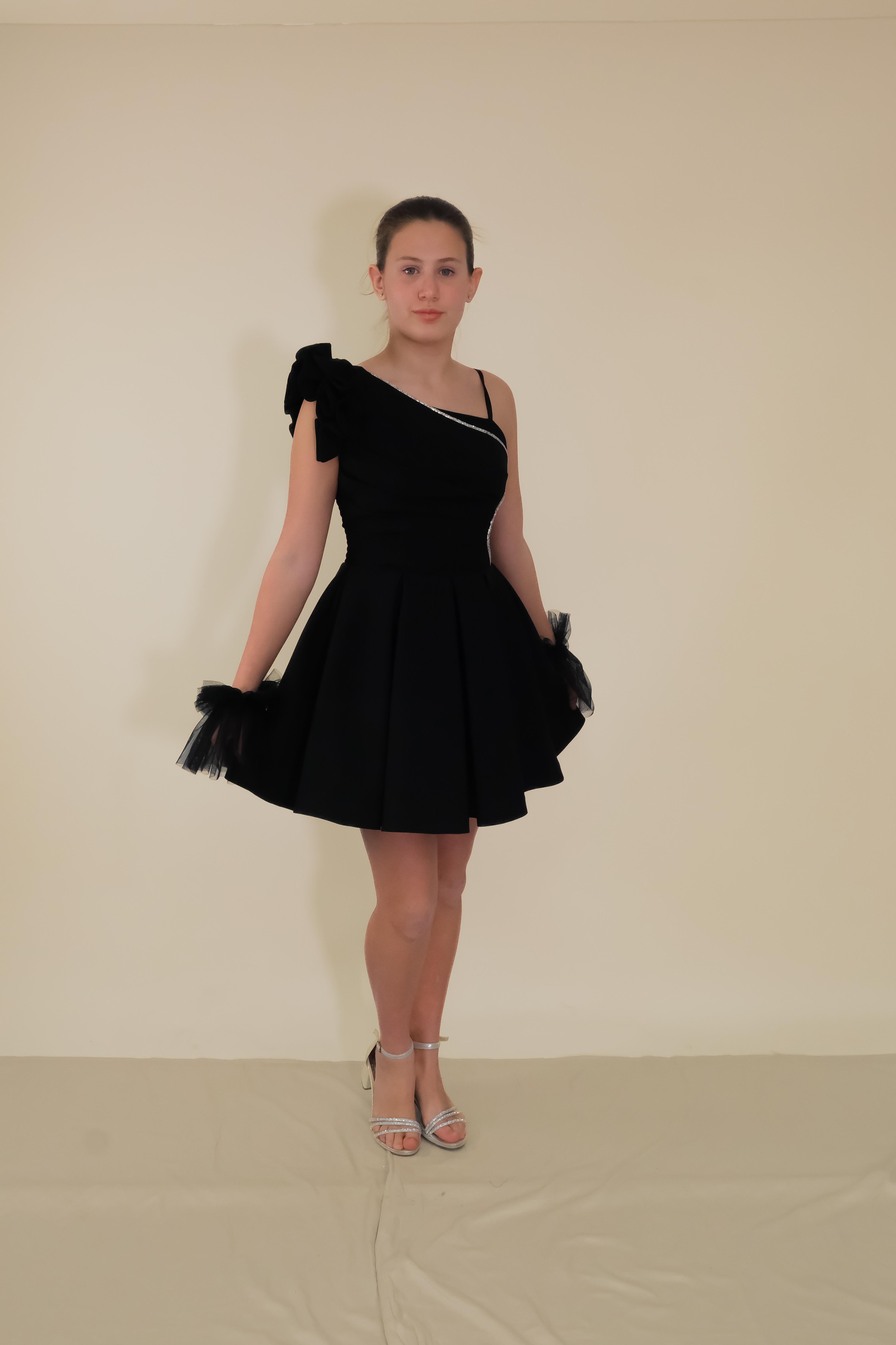 Kız Çocuk Abiye Siyah Askılı Krep Kumaş Tek Omuz Farbalı  Şerit Taş ve Tül Detaylı Eldivenli Kısa Abiye Elbise 10-15 Yaş