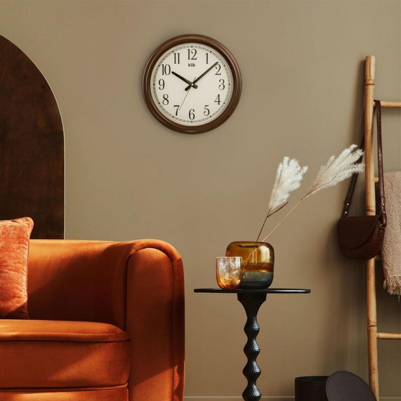 Yan açıdan kahverengi çerçeveli klasik duvar saati, beyaz kadran ve net rakamlar.