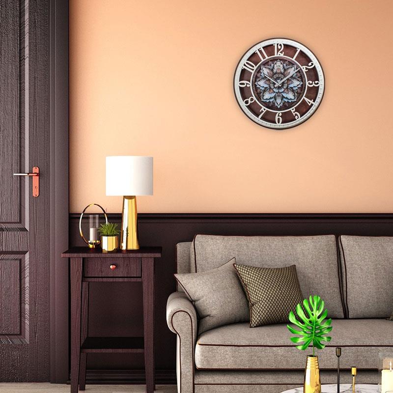 Modern bir salonda komodin üzerinde duran bir lamba yanında duvarda asılı Klik Hisar Lotus Çiçek Desenli duvar saati.