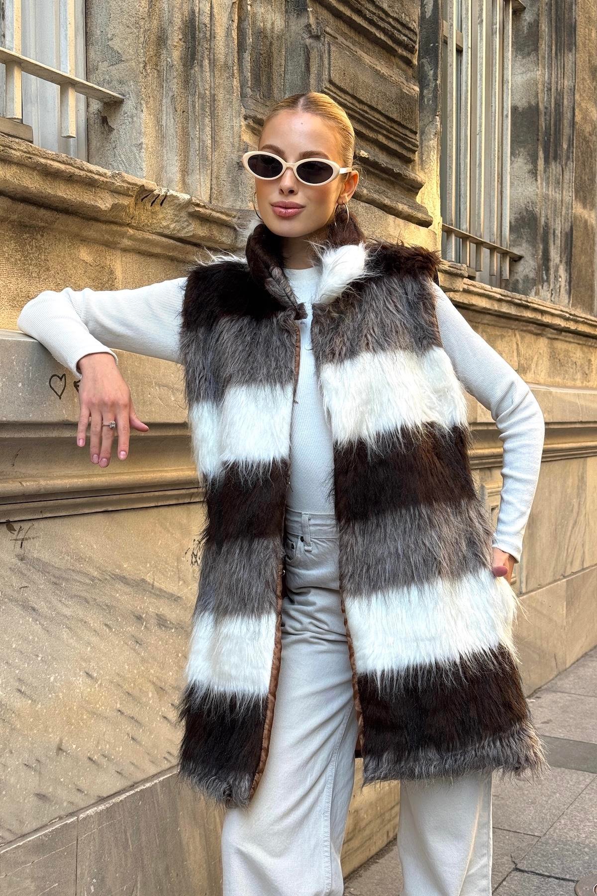 فيست طويل من الفرو الصناعي مخطط باللونين البني والأبيض بجيوب جلدية مفصلة باللون البيج